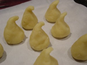 Ghost cake pops lined up on sheet pan