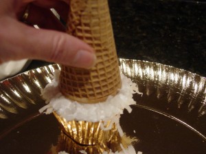 Putting a waffle cone on top of the Christmas Tree Cupcake