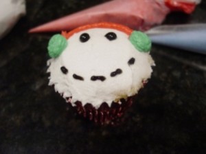 snowman cupcake with black pipng gel eyes and mouth