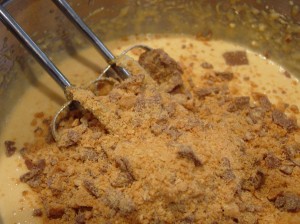 crushed butterfinger candies poured into cupcake batter