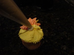 piping a turkey body with icing for turkey cupcakes starting at the base of the turkey feathers.