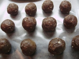 un-dipped maraschino cake bomb balls lined up on wax paper.
