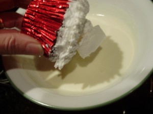 Santa cupcake being dipped in white chocolate