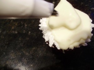using a # 18 cake decorators tip to create a Santa mustache for the Santa cupcake