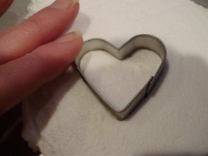 Heart Shaped Cookie Cutter Pressed into frozen icing for Santa face cupcake