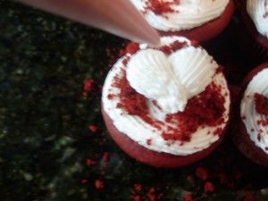 Red Velvet Cupcake with icing hearts layerd. One large white heart and one small red heart on top