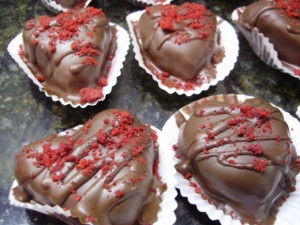 Red Velvet Cake Balls in shapes of hearts and dipped in chocolate